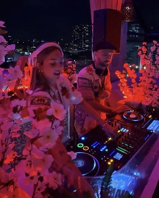 DJs among pink flowers on the rooftop